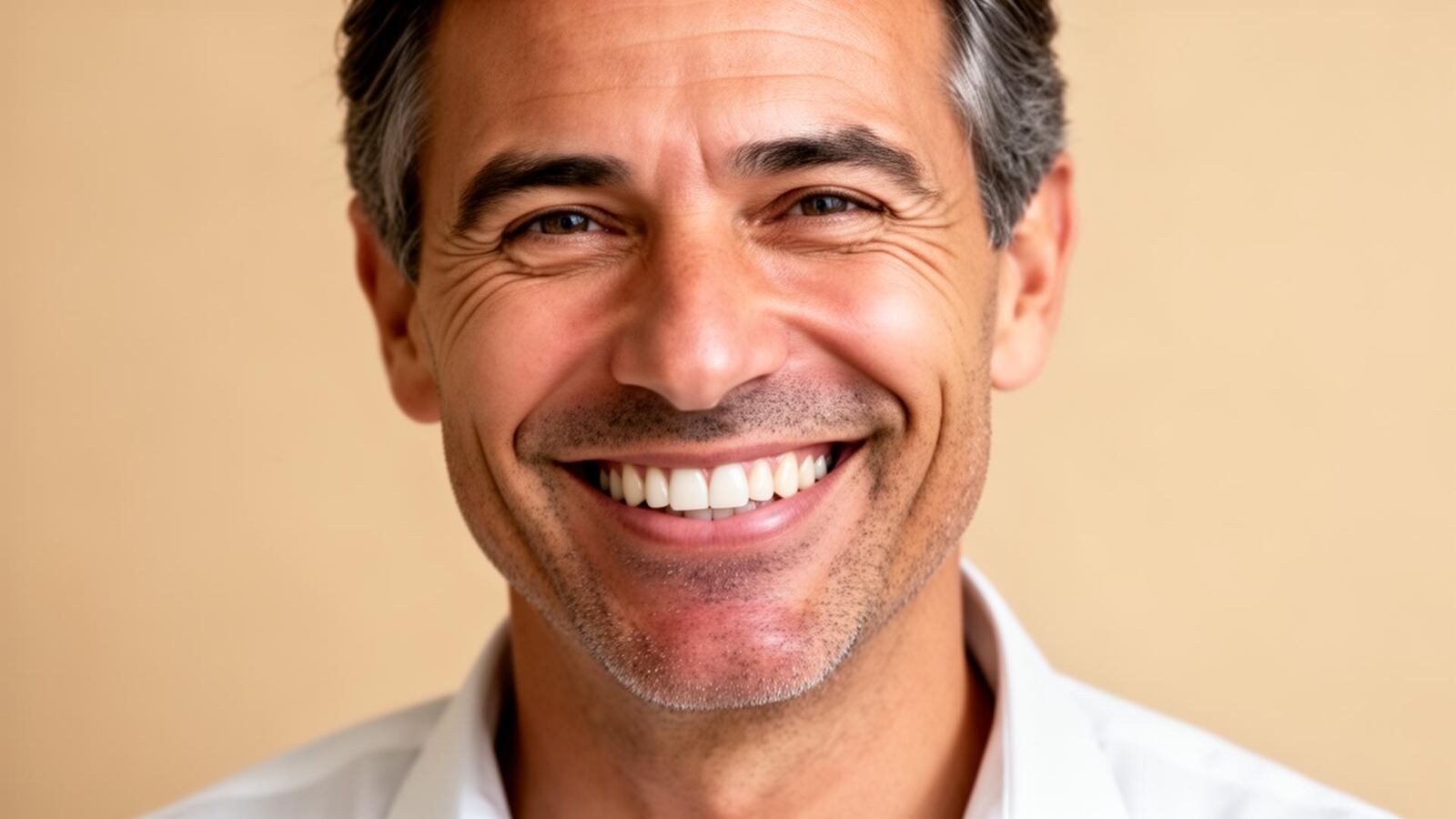 Confident smiling man with a restored natural smile, crowns and bridges